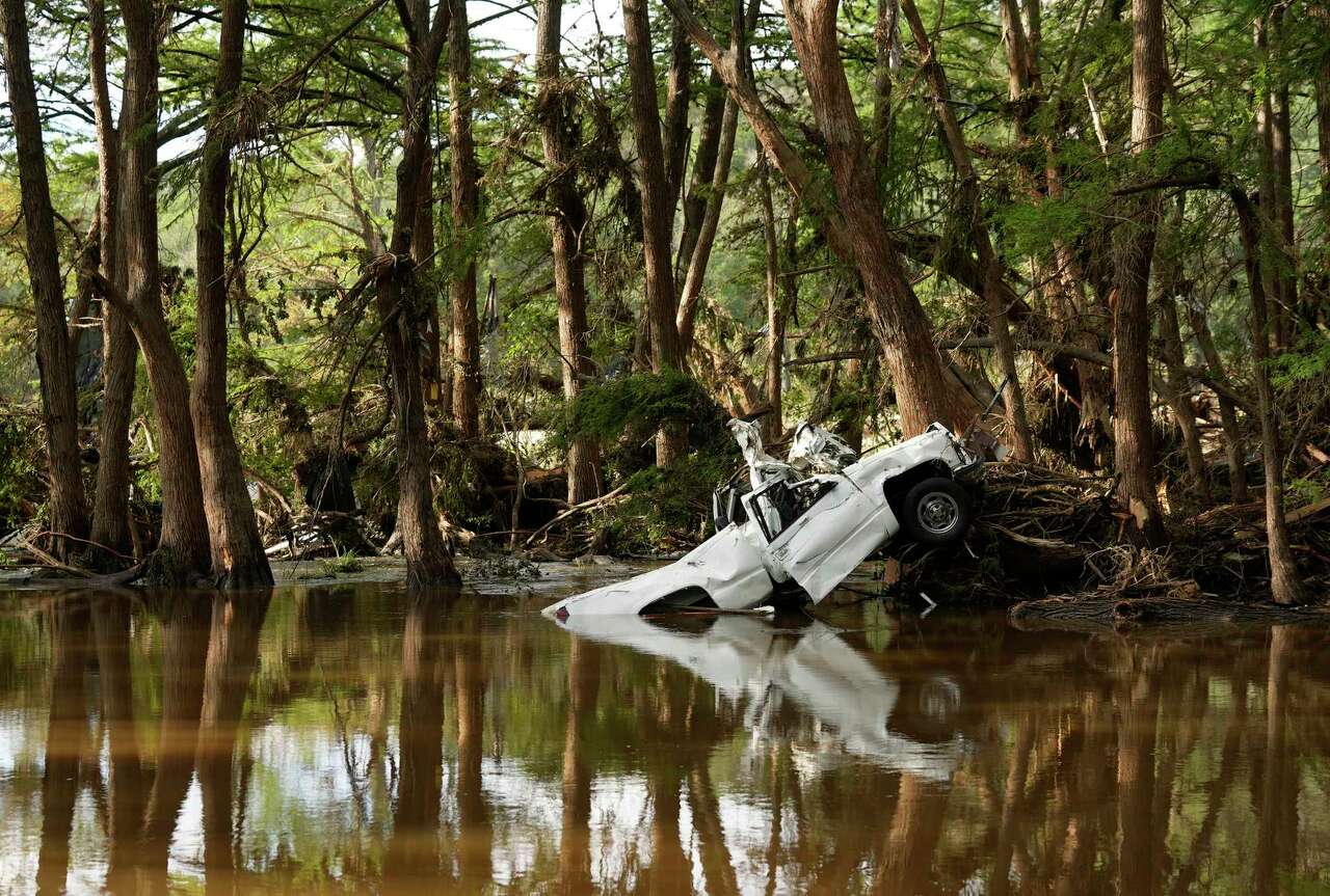 A truck is partially submerged in the Guadalupe River in Ingram, Tuesday, July 8, 2025, after the Fourth of July flood.