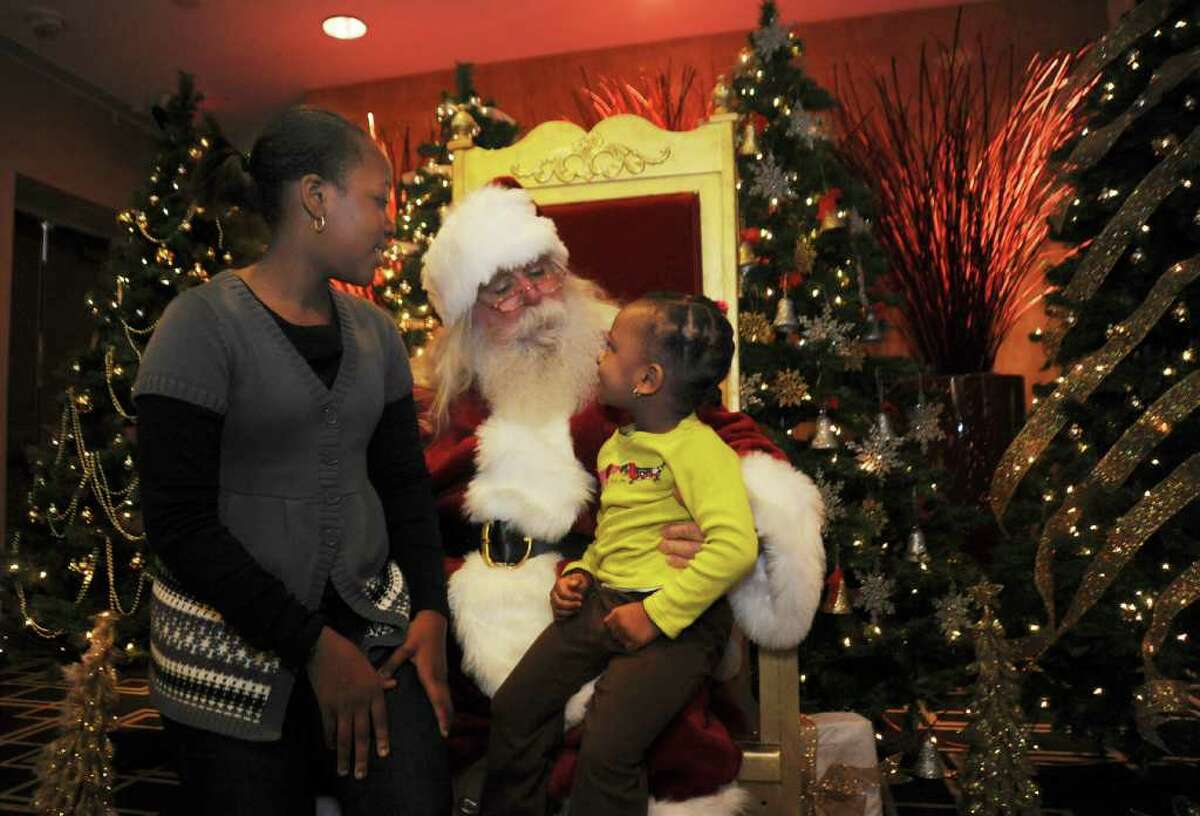 Yasmin Roche, 10, of Greenwich, left, and her sister Amaya, 3, talk to Santa Claus at the Junior League of Greenwich's benefit, "The Enchanted Forest," at the Hyatt Regency Greenwich, on Sunday, Nov. 21, 2010.