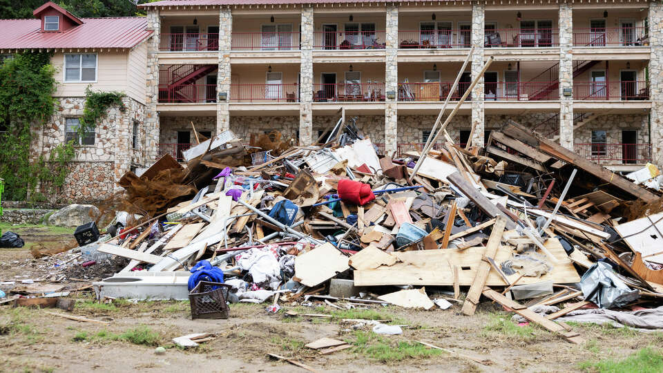 Debris cleared from a flood damaged building are seen in a large pile in Hunt, on Tuesday, July 15, 2025.