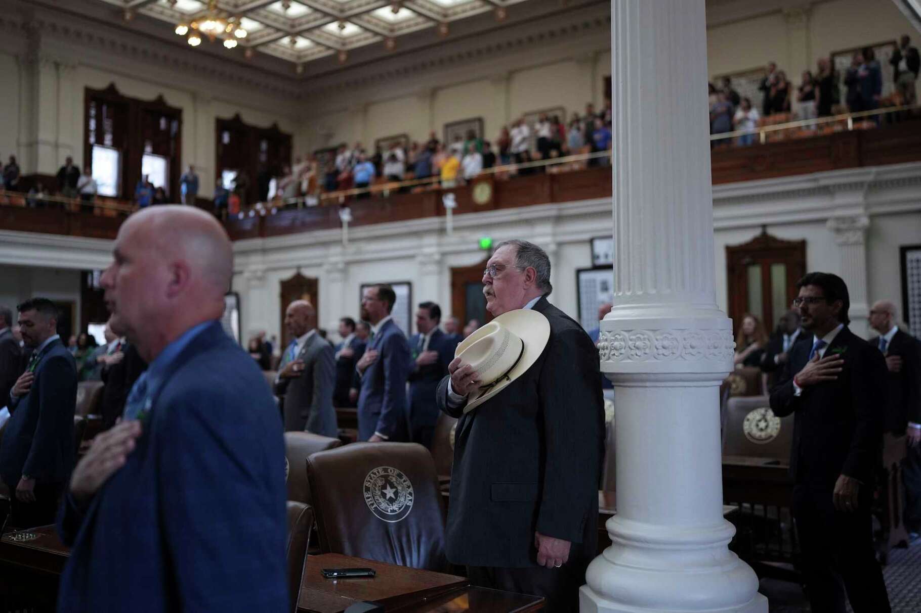 Texas State Rep. Cecil Bell, Jr., R-Magnolia, center and other house member stand for the pledge as the House calls a Special Session, Monday, July 21, 2025, in Austin. (AP Photo/Eric Gay)
