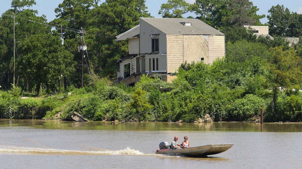 Boaters pass the Riverview at Forest Cove townhouse complex in the Kingwood area which was destroyed by floodwaters from Hurricane Harvey. It sits abandoned along the West Fork of the San Jacinto River east of Highway 59, Wednesday, Aug. 1, 2018 in Humble.