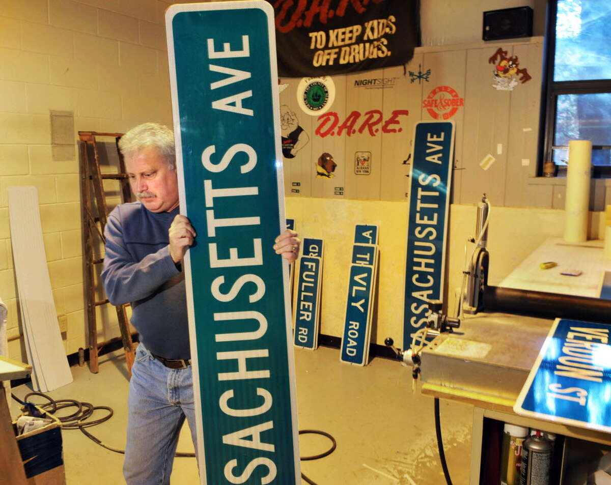 Sign technician Tom Phelan with new street signs in the sign shop at the Colonie Public Operation Center. (John Carl D'Annibale / Times Union)