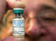 FILE - In this Thursday, Jan. 29, 2015 file photo, a pediatrician holds a dose of the measles-mumps-rubella (MMR) vaccine at his practice in Northridge, Calif. (AP Photo/Damian Dovarganes, File)