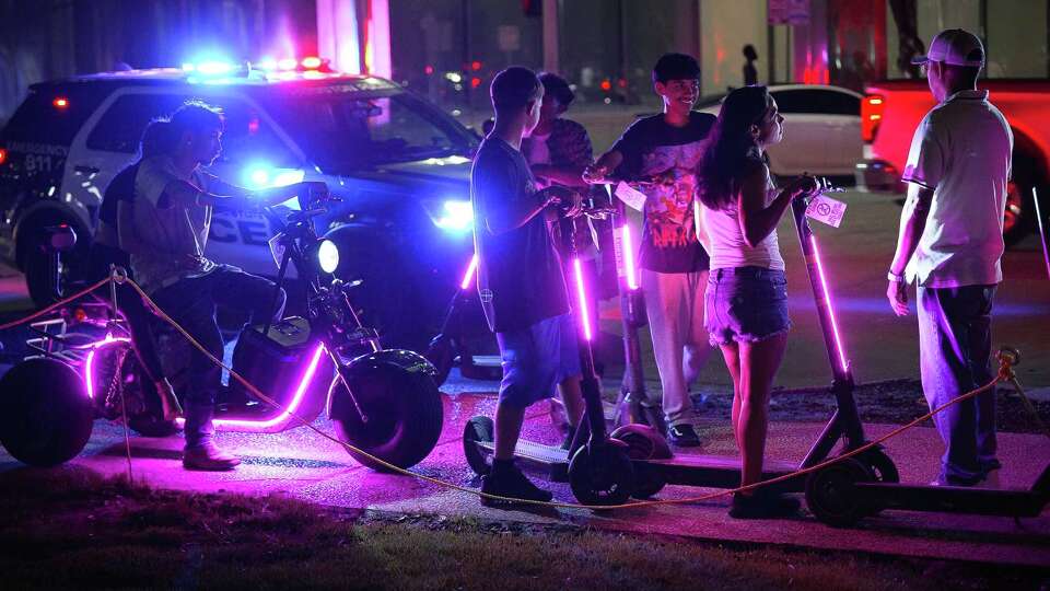People ride e-scooters and other electric vehicles around Discovery Green in Houston, Texas on Friday July 26, 2025. Mayor John Whitmire’s administration has proposed an outright ban on e-scooters in downtown and surrounding neighborhoods.