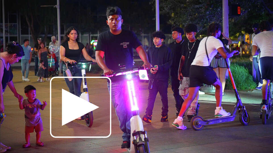 People ride e-scooters and other electric vehicles around Discovery Green in Houston, Texas on Saturday July 26, 2025. Mayor John Whitmire’s administration has proposed an outright ban on e-scooters in downtown and surrounding neighborhoods.
