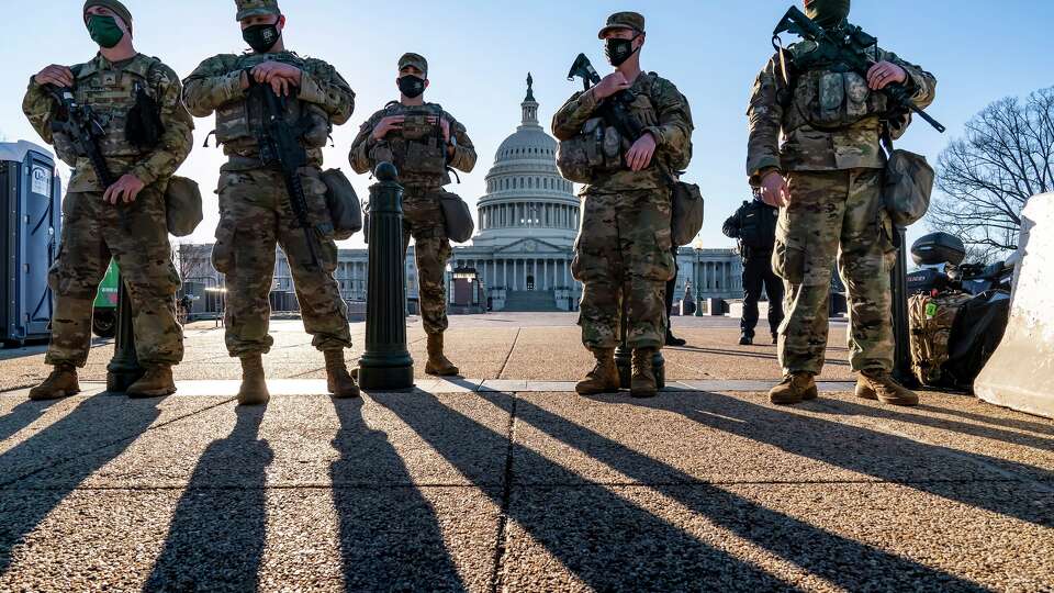 FILE - National Guard troops and the U.S. Capitol Police keep watch as heightened security remains in effect around the Capitol grounds in Washington, March 3, 2021.