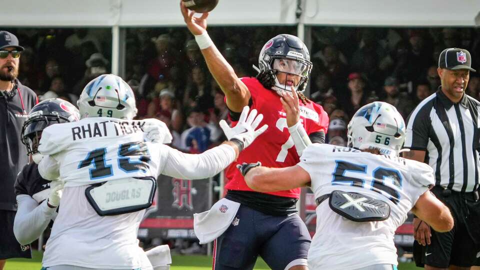 Houston Texans quarterback C.J. Stroud (7) passes over Carolina Panthers linebacker Jon Rhattigan and Christian Rozeboom (56) for a touchdown pass to wide receiver Nico Collins during an NFL training camp practice at Houston Methodist Training Center in Houston, Thursday, Aug. 14, 2025.