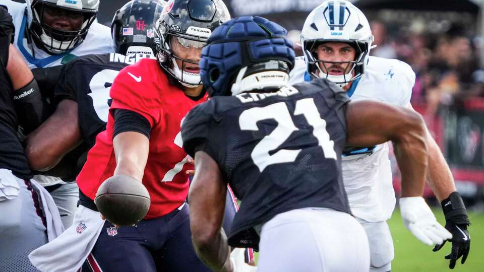 Houston Texans quarterback C.J. Stroud (7) hands the ball off to running back Nick Chubb (21) as they work against the Carolina Panthers defense during an NFL training camp practice at Houston Methodist Training Center in Houston, Thursday, Aug. 14, 2025.