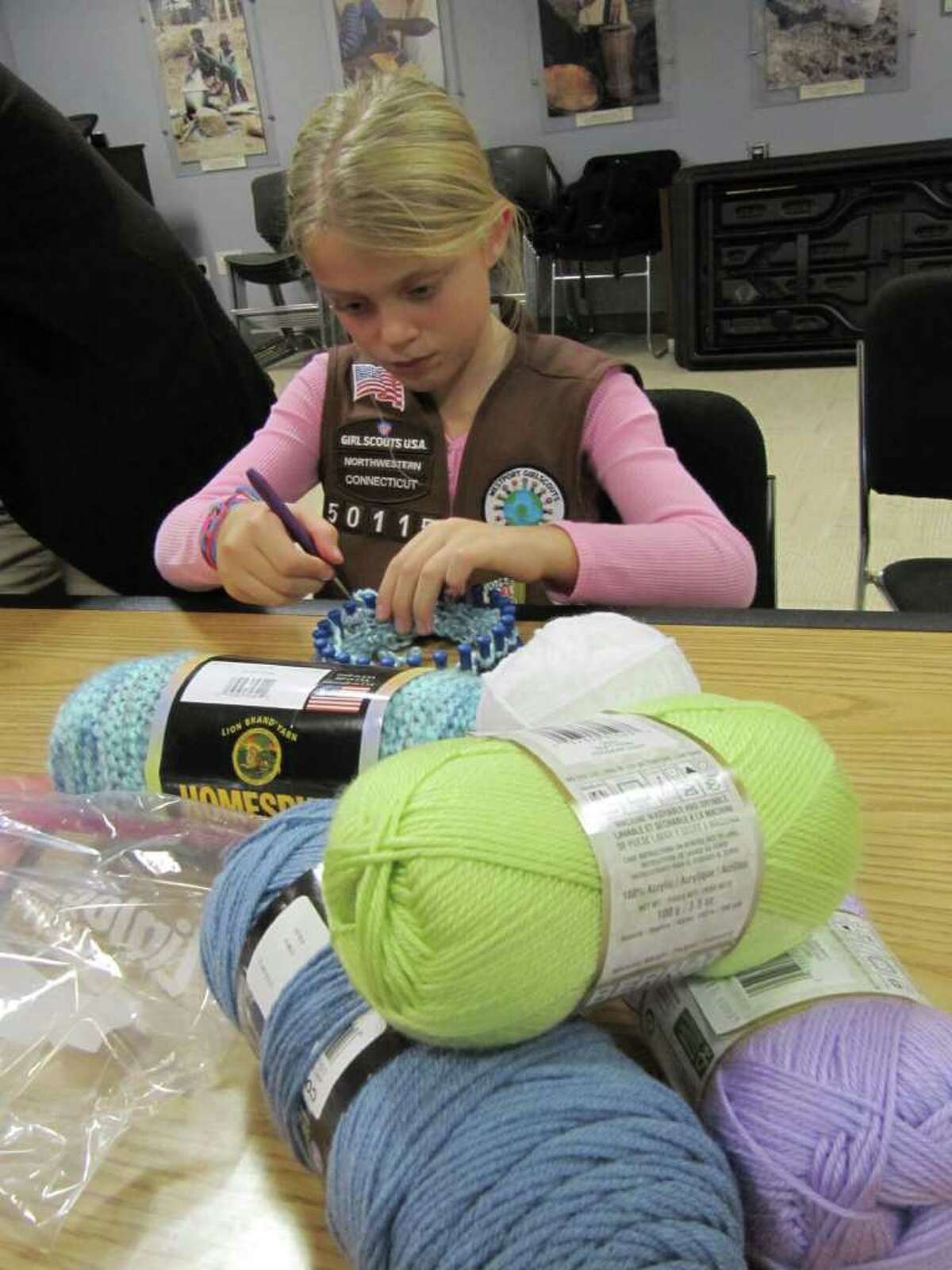 Hannah Paprotna, a member of Brownie Troop 50115, makes a cap for an infant child in a developing country. The effort is part of Save the Children's "Caps For Good" campaign.