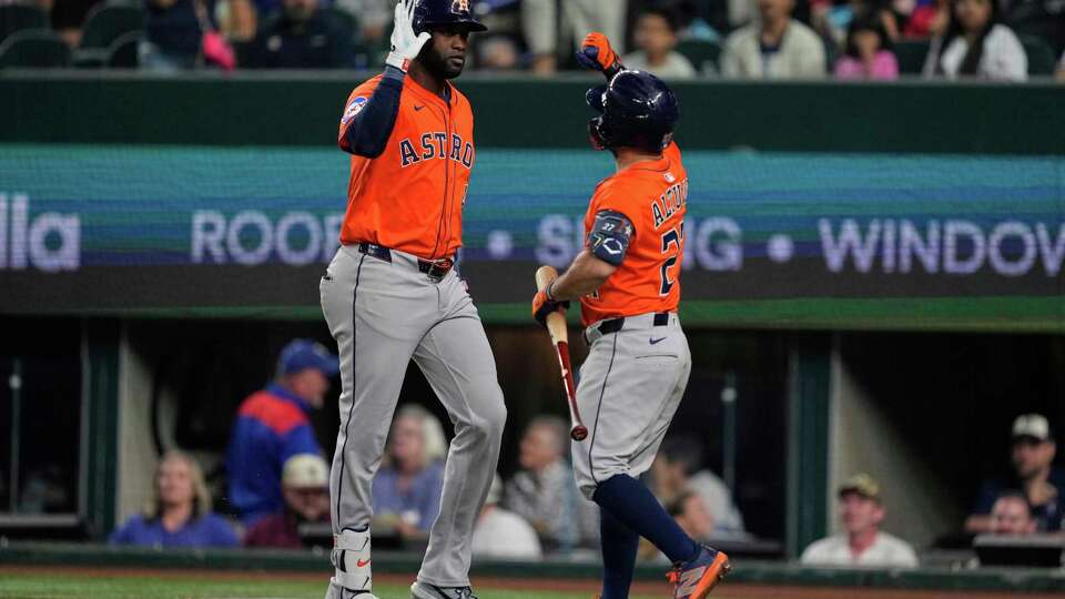 Houston Astros' Yordan Alvarez, left, and Jose Altuve (27) celebrate after Alvarez hit a solo home run in the fifth inning of a baseball game against the Texas Rangers Saturday, Sept. 6, 2025, in Arlington, Texas. (AP Photo/Tony Gutierrez)