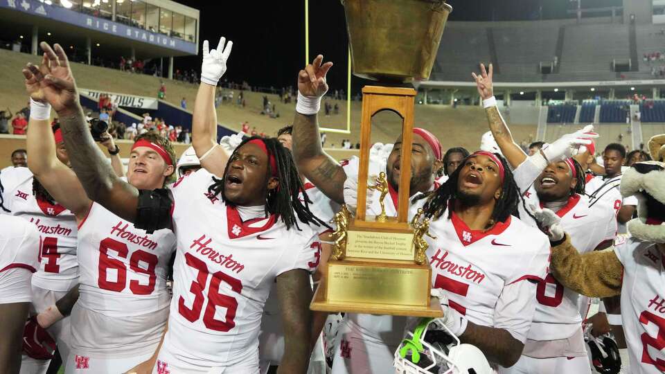 Houston wide receiver Stephon Johnson (5) holds up the Bayou Bucket trophy after the Cougars defeated the Rice Owls 35-9 during an NCAA college football game in Houston, Saturday, Sept. 6, 2025.