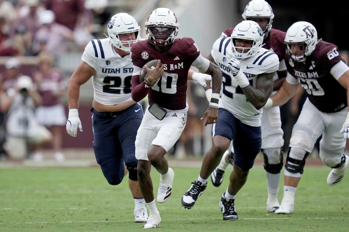 Texas A&M quarterback Marcel Reed (10) scrambles away from Utah State defensive tackle Carson Tujague (28) and linebacker William Holmes (24) for a first down during the first quarter of an NCAA college football game Saturday, Sept. 6, 2025, in College Station, Texas. (AP Photo/Sam Craft)