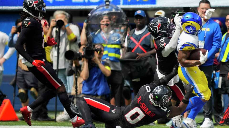 Houston Texans safety Calen Bullock (2) and linebacker Azeez Al-Shaair (0) knock Los Angeles Rams running back Kyren Williams (23) out of bounds during the first half of an NFL football game at SoFi Stadium in Inglewood, Calif., Sunday, Sept. 7, 2025.