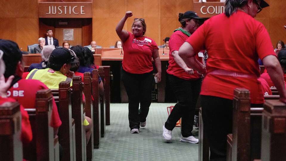 Paloma Medina, an organizer with Unite Here Local 23, holds up a fist during a Houston City Council public session on Tuesday, Sept. 9, 2025.
