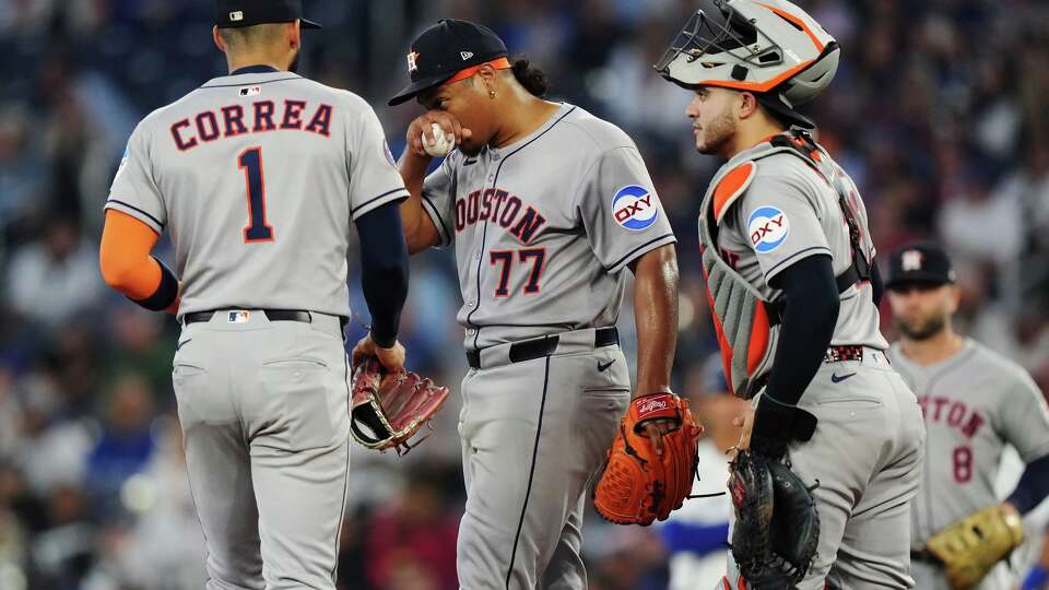 Houston Astros pitcher Luis Garcia (77) is visited by teammates on the mound before leaving the game against the Toronto Blue Jays during second inning MLB baseball action in Toronto on Tuesday, Sept. 9, 2025. (Nathan Denette/The Canadian Press via AP)