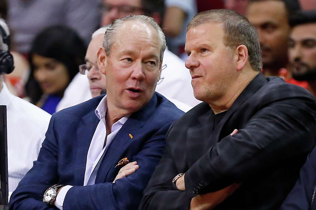 Houston Astros owner Jim Crane and Houston Rockets owner Tilman Fertitta chat about being billionaires while sitting courtside at a game. (Probably.)