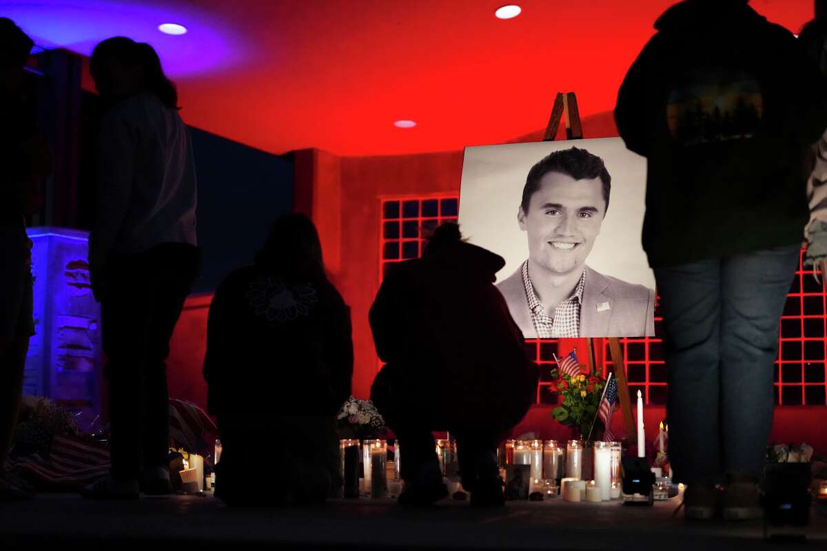 People place lit candles below a photo of Charlie Kirk, the CEO and co-founder of Turning Point USA who was shot and killed, at a vigil in his memory, Thursday, Sept. 11, 2025, in Orem, Utah.