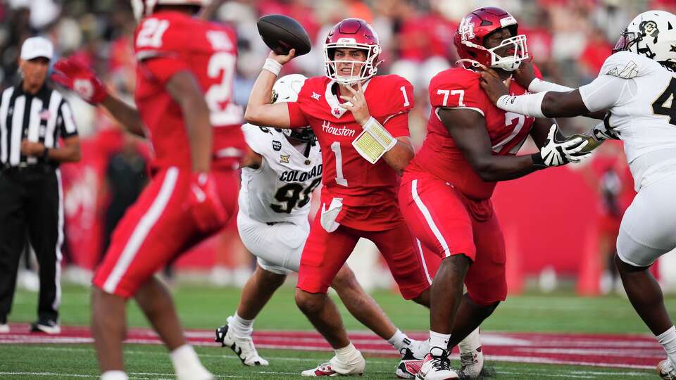 Houston quarterback Conner Weigman (1) throws under pressure by Colorado defensive end Alexander McPherson (98) to running back Stacy Sneed during the first half of a Big 12 Conference college football game in Houston, Friday, Sept. 12, 2025.