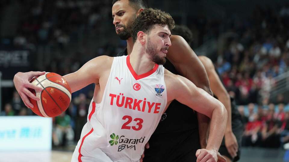 Turkey's Alperen Sengun, front, drives to the basket as Germany's Johannes Thiemann tries to block him during the Eurobasket, European Basketball Championship final match between Turkey and Germany at the Riga Arena in Riga, Latvia, Sunday, Sept. 14, 2025. (AP Photo/Sergei Grits)