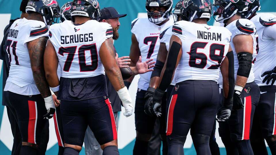 Houston Texans offensive line coach Cole Popovich works with the offensive line while warming up before an NFL football game against the Jacksonville Jaguars at Everbank Stadium in Jacksonville, Fla., Sunday, Sept. 21, 2025.