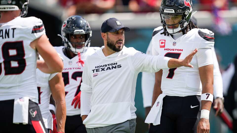 Houston Texans offensive coordinator Nick Caley works with quarterback C.J. Stroud (7) while warming up before an NFL football game against the Jacksonville Jaguars at Everbank Stadium in Jacksonvillew, Fla., Sunday, Sept. 21, 2025.