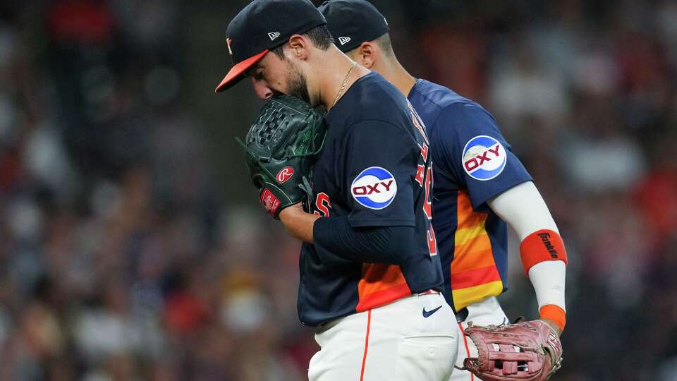 Houston Astros starting pitcher Jason Alexander, left, reacts alongside third baseman Carlos Correa as manager Joe Espada comes out to pull Alexander during the second inning of a MLB baseball game in Houston, Sunday, Sept. 21, 2025.