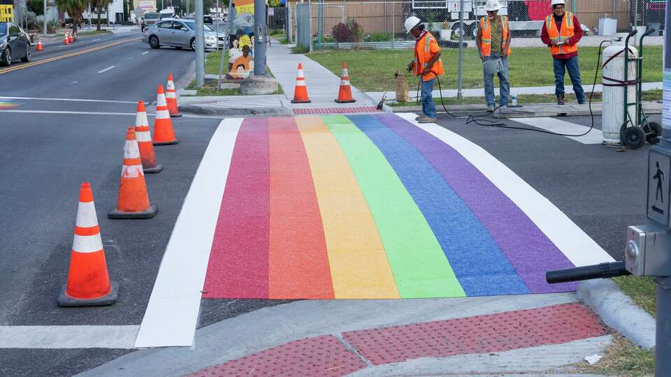 Workers are seen as the rainbow crosswalk is repainted at Westheimer Road and Taft Street in Houston, Wednesday, Oct. 1, 2025.