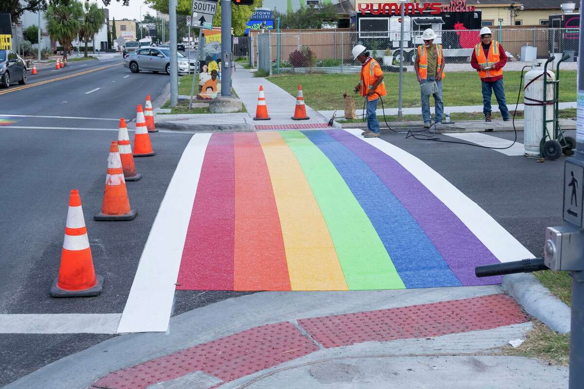 Workers are seen as the rainbow crosswalk is repainted at Westheimer Road and Taft Street in Houston, Wednesday, Oct. 1, 2025.
