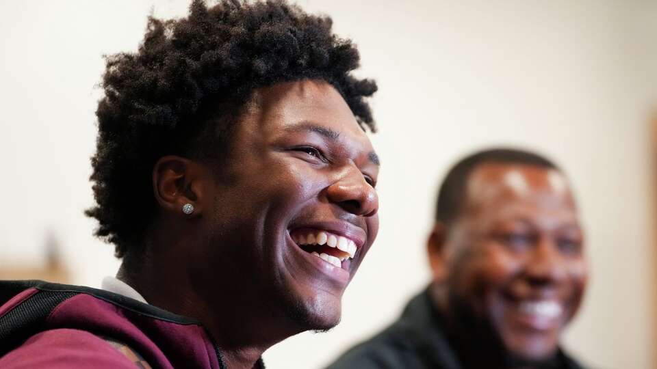Legacy quarterback Keisean Henderson, one of the top quarterback recruit in state, laughs alongside his coach, Michael Bishop, in Spring, Thursday, Oct. 2, 2025. Henderson is committed to the University of Houston.