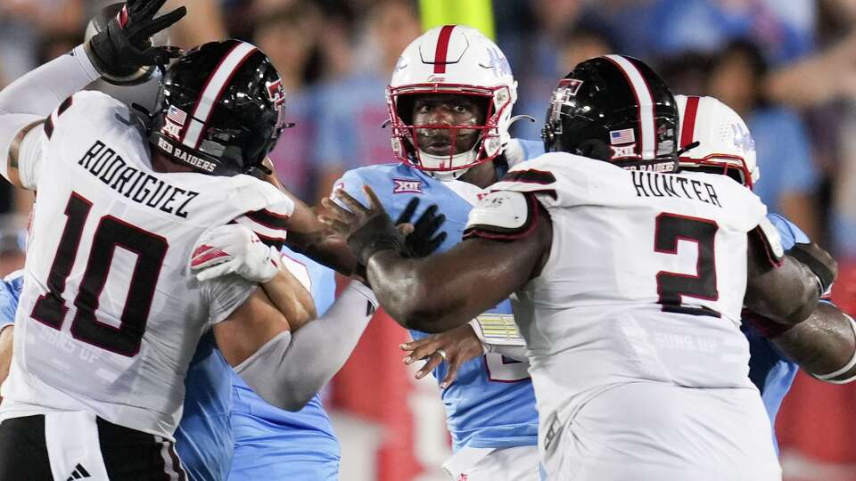 Houston quarterback Zeon Chriss-Gremillion (2) looks to throw under pressure by Texas Tech linebacker Jacob Rodriguez (10) and defensive tackle Lee Hunter (2) during the second half of a NCAA college football game in Houston, Saturday, Oct. 4, 2025.