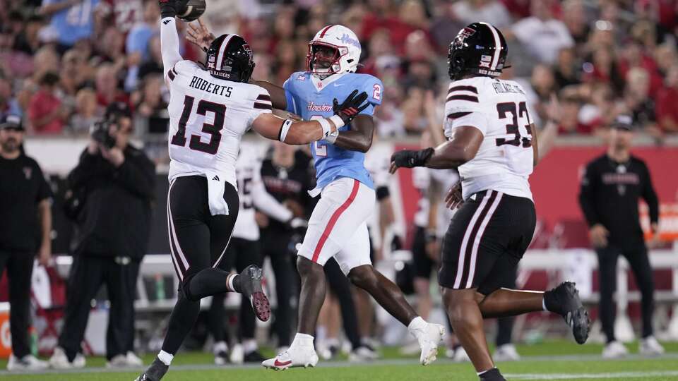 Houston quarterback Zeon Chriss-Gremillion (2) throws under pressure by Texas Tech linebacker Ben Roberts (13) during the second half of a NCAA college football game in Houston, Saturday, Oct. 4, 2025.