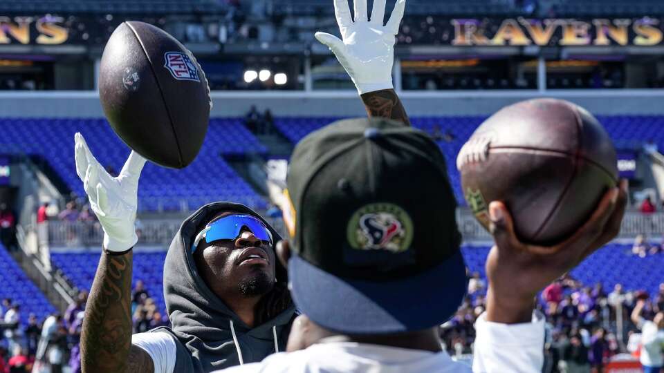 Houston Texans safety Calen Bullock, left, warms up before an NFL football game against the Baltimore Ravens at M&T Bank Stadium in Baltimore, Sunday, Oct. 5, 2025.