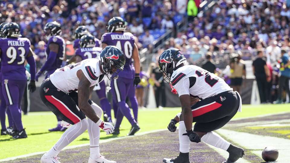 Houston Texans wide receiver Nico Collins (12) and running back Woody Marks (27) celebrate Collins’ 10-yard touchdown reception against the Baltimore Ravens during the first half of an NFL football game at M&T Bank Stadium in Baltimore, Sunday, Oct. 5, 2025.