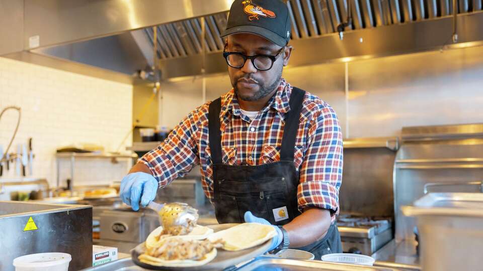Chef Ryan Grimes spoons jerk chicken onto tortillas at Third Place.