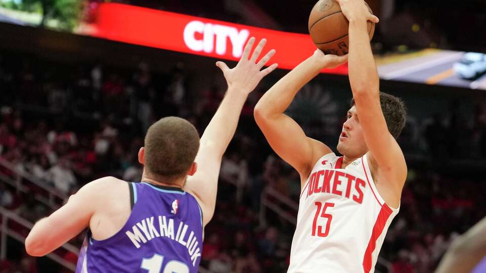 Houston Rockets guard Reed Sheppard (15) shoots over Utah Jazz guard Svi Mykhailiuk (10) during the second half of a preseason NBA basketball game in Houston, Wednesday, Oct. 8, 2025.