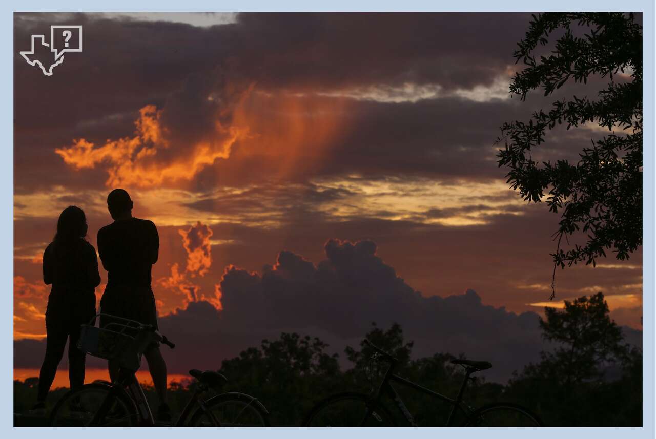 Couple Zayda Cortez, left, and Allen Alejandro watch the sunset over Eleanor Tinsley Park Tuesday, June 27, 2017 in Houston.