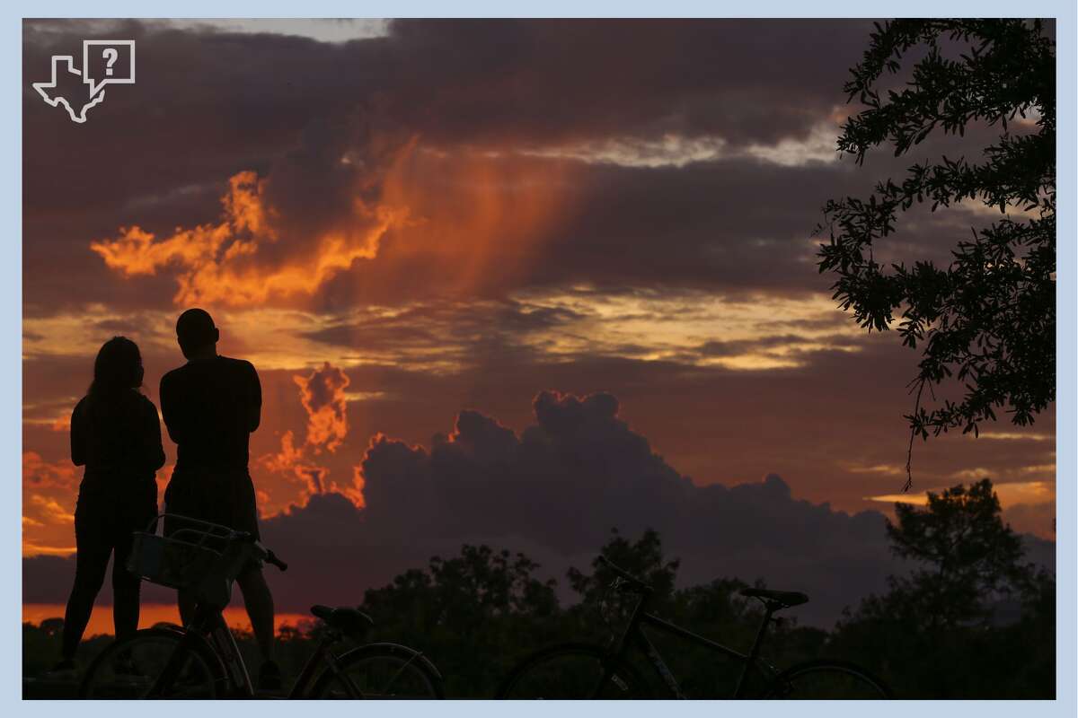 Couple Zayda Cortez, left, and Allen Alejandro watch the sunset over Eleanor Tinsley Park Tuesday, June 27, 2017 in Houston.