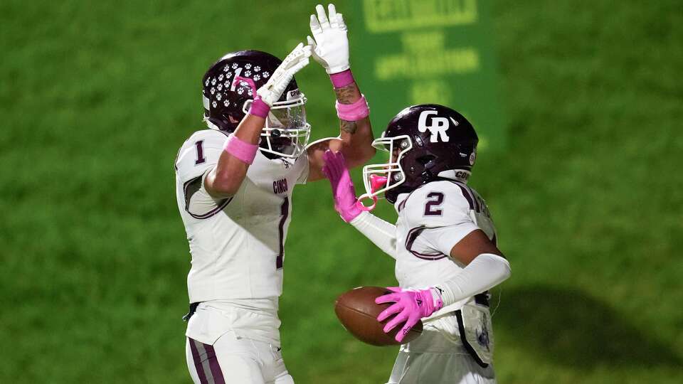 Cinco Ranch wide receiver Jacob Chevez, right, celebrates wit running back Brayden Gonzalez after catching a 9-yard touchdown during the first half of a District 19-6A high school football game in Katy, Friday, Oct. 10, 2025.