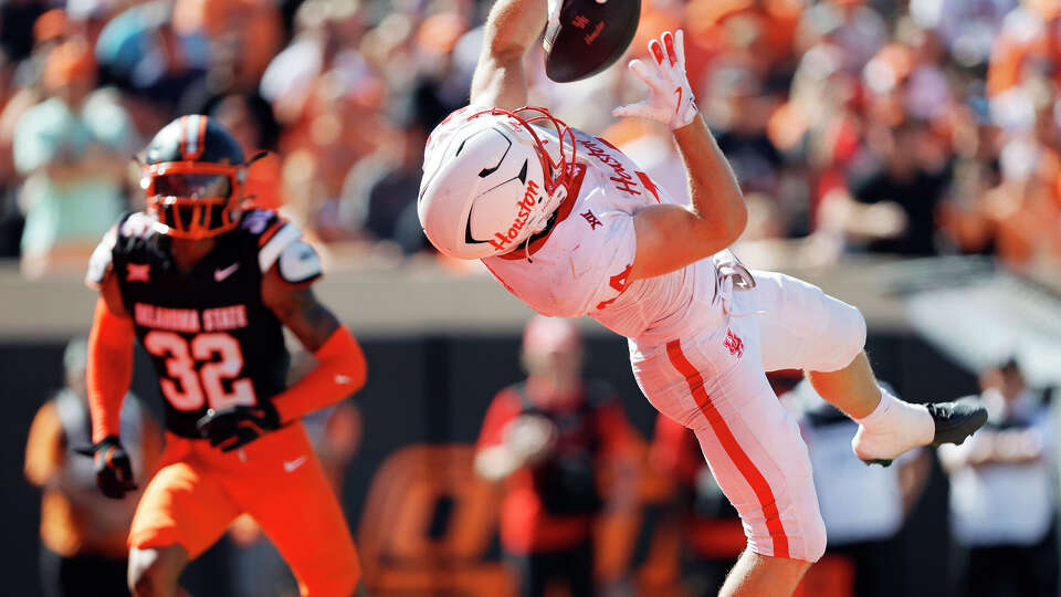 Running back Dean Connors of the Houston Cougers pulls down a six-yard touchdown catch against safety Mordecai McDaniel of the Oklahoma State Cowboys in the second quarter at Boone Pickens Stadium on October 11, 2025 in Stillwater, Oklahoma. Houston leads 24-10 at the half.