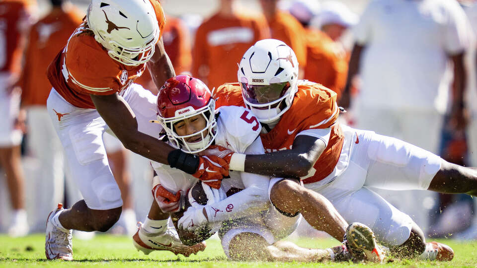 The Texas defense bring down Oklahoma Sooners wide receiver Isaiah Sategna III (5) in the first quarter of the Red River Rivalry, as the Sooners play the Longhorns at the Cotton Bowl in Dallas, Oct. 11, 2025.