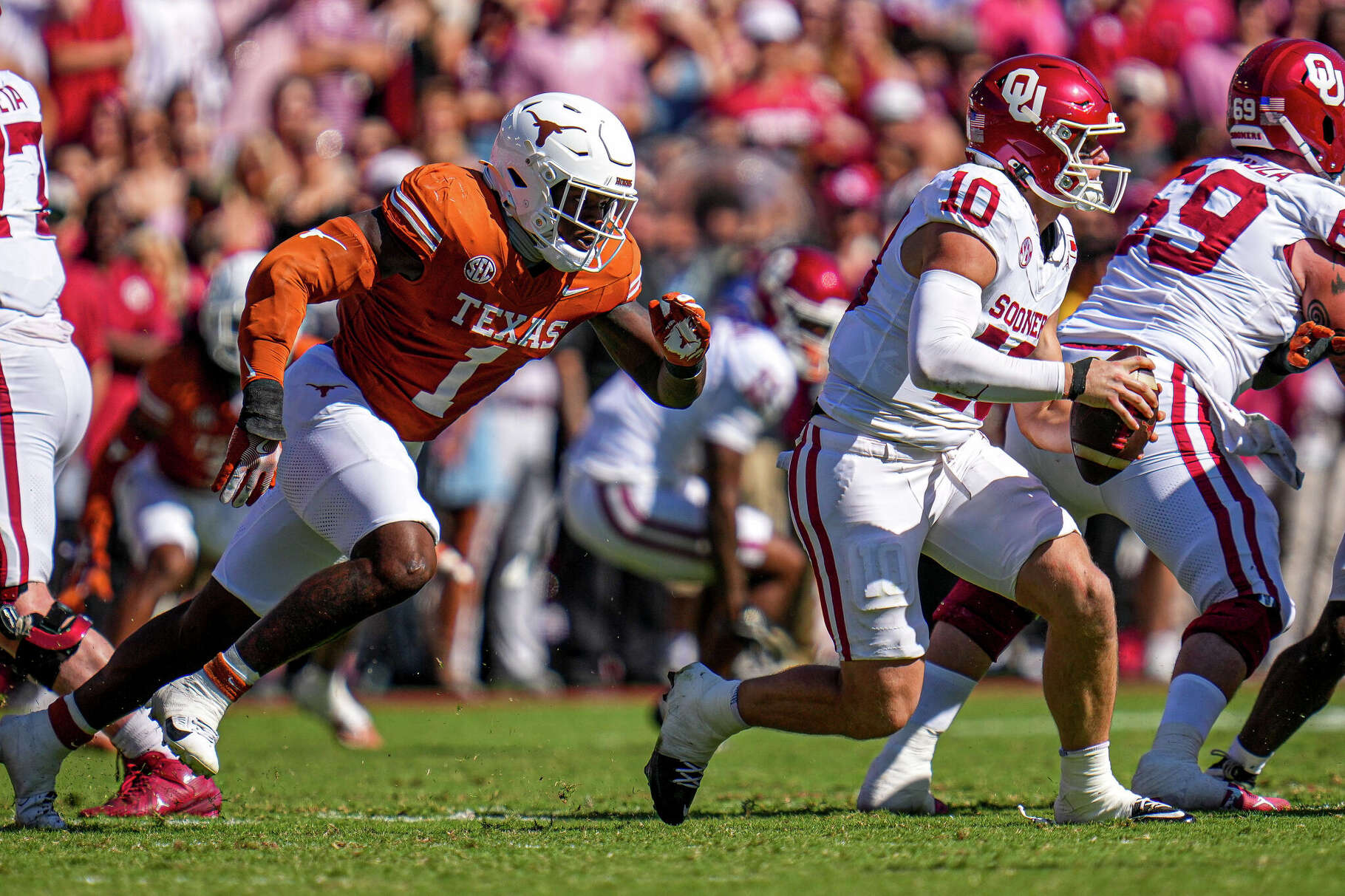Oklahoma Sooners quarterback John Mateer (10) is pressured by Texas Longhorns linebacker Colin Simmons (1) during the Red River Rivalry between the Texas Longhorns and Oklahoma Sooners at the Cotton Bowl on Saturday Oct. 11, 2025 in Dallas, Texas.