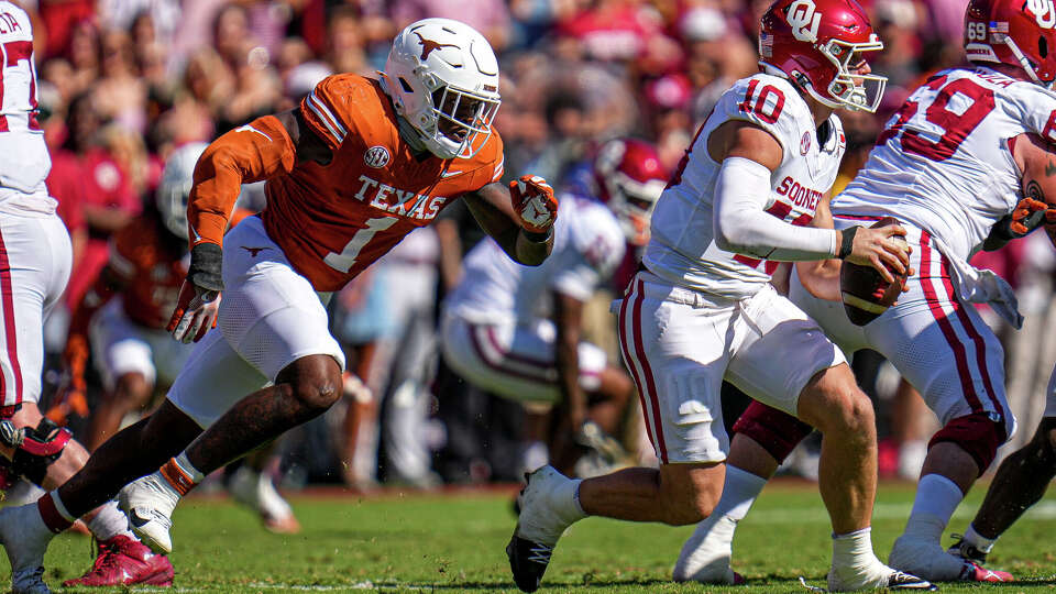 Oklahoma Sooners quarterback John Mateer (10) is pressured by Texas Longhorns linebacker Colin Simmons (1) during the Red River Rivalry between the Texas Longhorns and Oklahoma Sooners at the Cotton Bowl on Saturday Oct. 11, 2025 in Dallas, Texas.