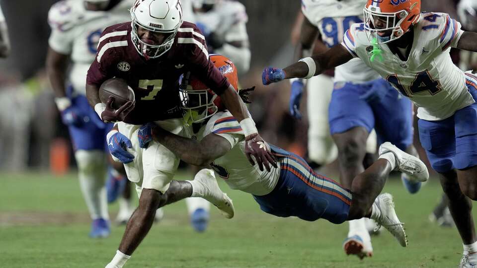 Texas A&M wide receiver KC Concepcion (7) drags Florida safety Bryce Thornton (18) for a first down after a catch and run during the second half of an NCAA college football game Saturday, Oct. 11, 2025, in College Station, Texas. (AP Photo/Sam Craft)