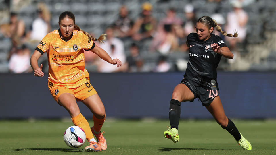 Delanie Sheehan #8 of Houston Dash is challenged by Gisele Thompson #20 of Angel City FC during the NWSL match between Angel City FC and Houston Dash at BMO Stadium on October 12, 2025 in Los Angeles, California.