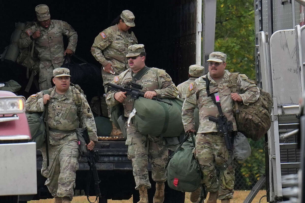 Military personnel in uniform, with the Texas National Guard patch on, are seen at the U.S. Army Reserve Center, Tuesday, Oct. 7, 2025, in Elwood, Ill., a suburb of Chicago. 