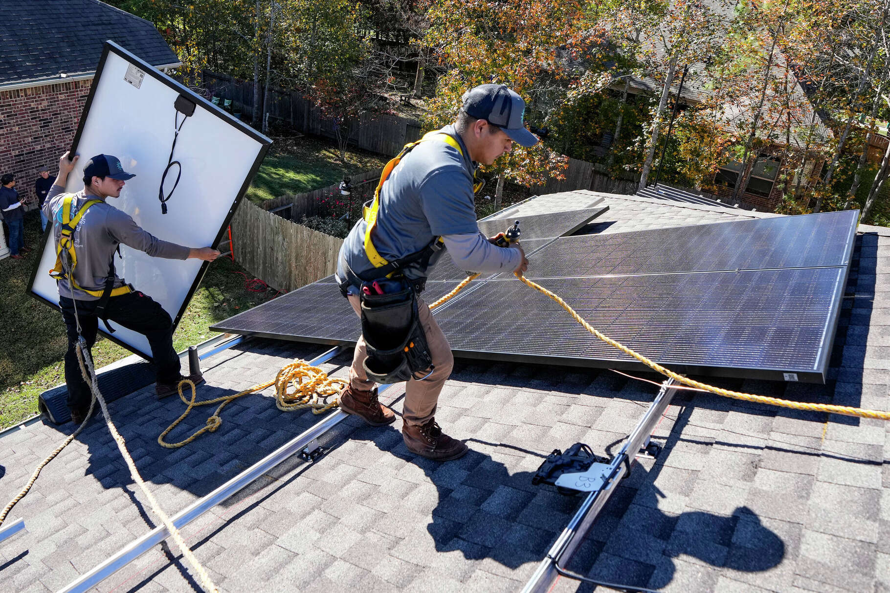 Julian Guerrero, left, and Gerardo Godinez, of True Texas Solar, install solar panels on Monday, Dec. 11, 2023 in Conroe.