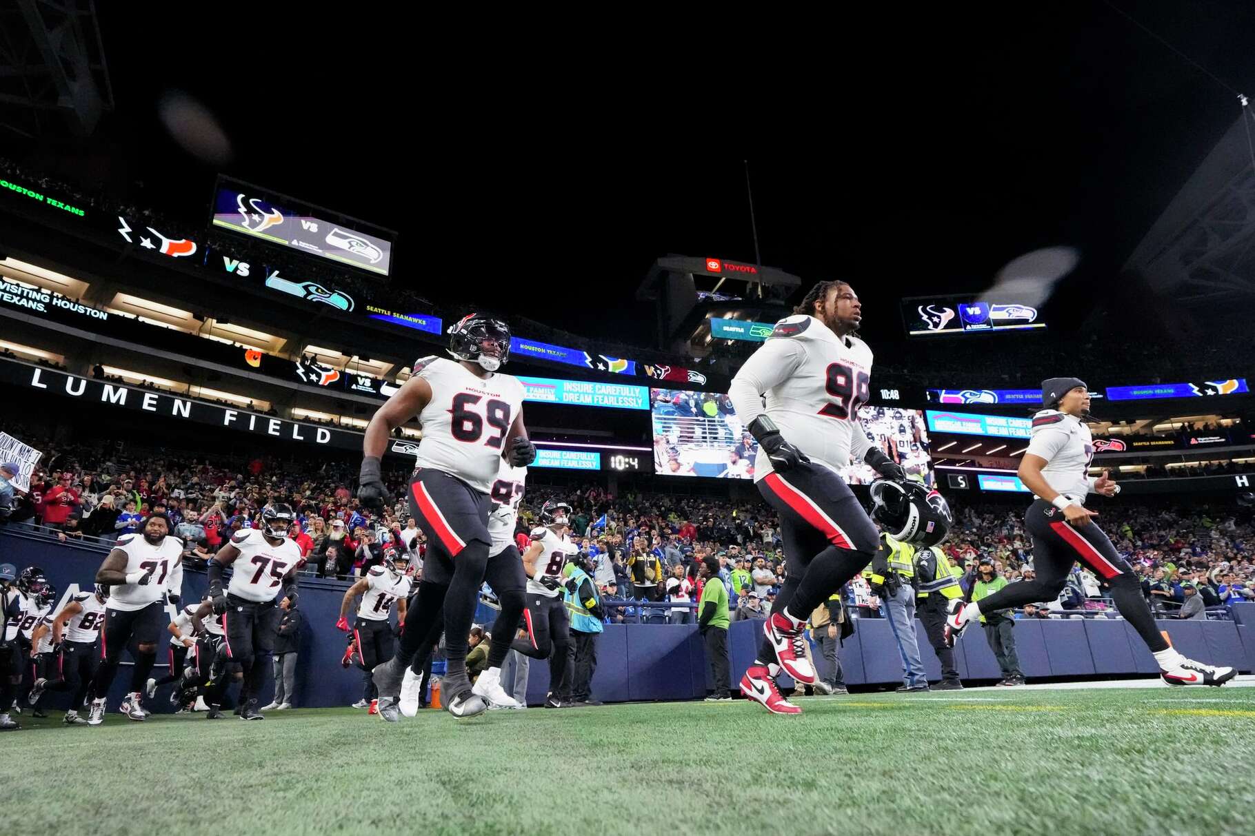 Houston Texans quarterback C.J. Stroud, right, takes the field alongside defensive tackle Tim Settle (98) and guard Ed Ingram (69) before an NFL football game, Monday, Oct. 20, 2025, in Seattle.