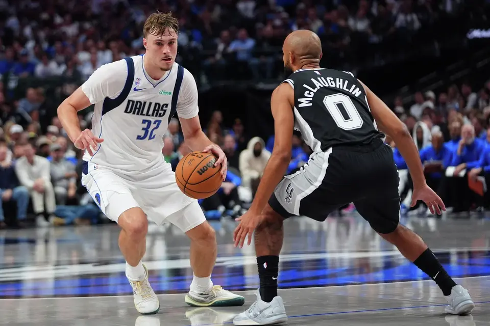 Dallas Mavericks forward Cooper Flagg (32) dribbles against San Antonio Spurs guard Jordan McLaughlin (0) during the second half of an NBA basketball game in Dallas, Wednesday, Oct. 22, 2025. (AP Photo/LM Otero)