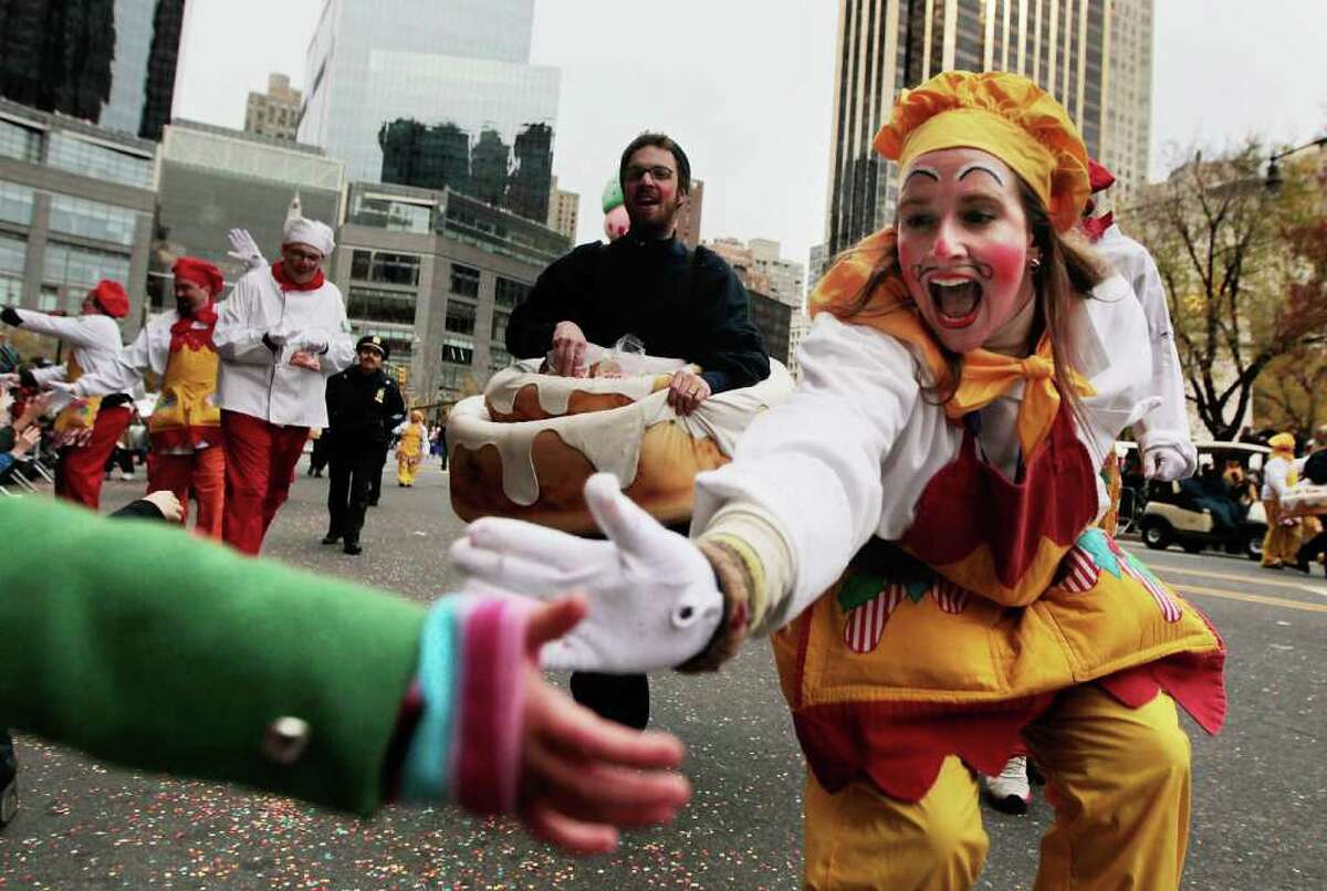 NEW YORK - NOVEMBER 25: A performer shakes hands with children during the Macy's Thanksgiving Day parade November 25, 2010 in New York City. The 84th annual celebration featured approximately 8,000 participants including more 1,600 cheerleaders and dancers, twelve marching bands, and an assortment of celebrities in addition to 15 giant character balloons. (Photo by Chris Hondros/Getty Images)