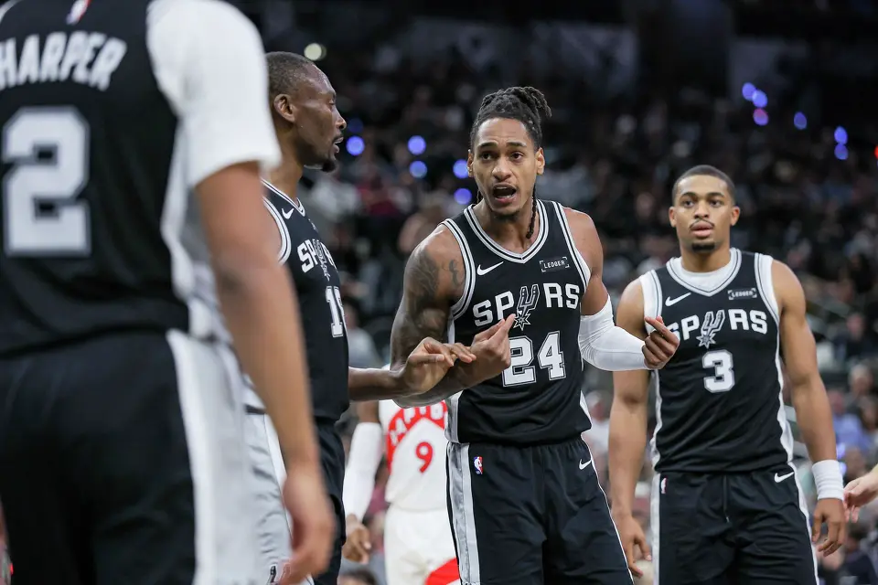 San Antonio Spurs guard Devin Vassell (24), center, talks to his teammates guard Dylan Harper (2), center Bismack Biyombo (18) and forward Keldon Johnson (3) after a defensive foul is called on the Spurs’ during an NBA game against the Toronto Raptors at Frost Bank Center in San Antonio, Monday, Oct. 27, 2025.